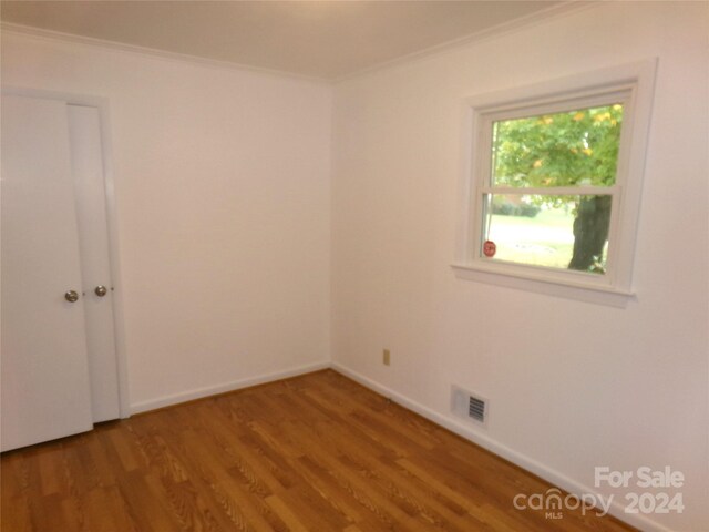 unfurnished room featuring hardwood / wood-style flooring and ornamental molding