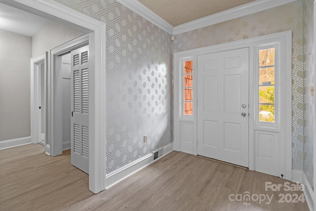 entryway with light wood-type flooring and crown molding