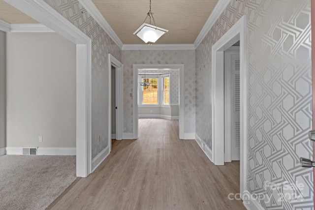 hallway with light hardwood / wood-style flooring and crown molding