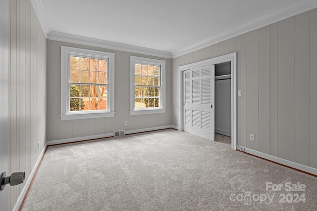 unfurnished bedroom featuring light carpet, a closet, and crown molding