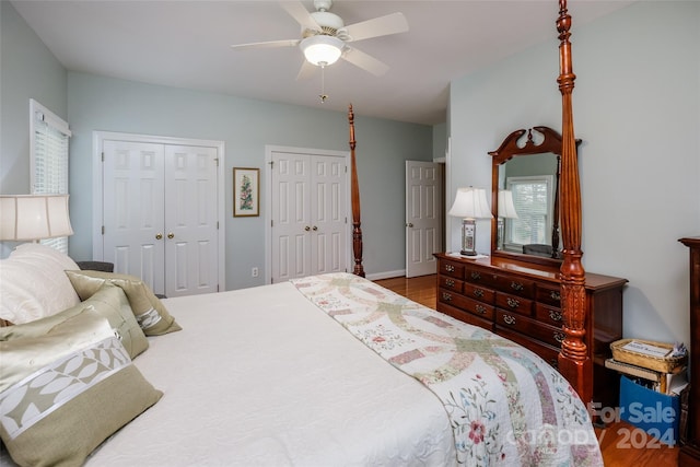 bedroom featuring ceiling fan, wood-type flooring, and two closets