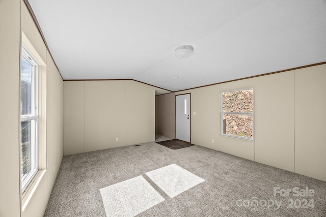 carpeted empty room featuring lofted ceiling