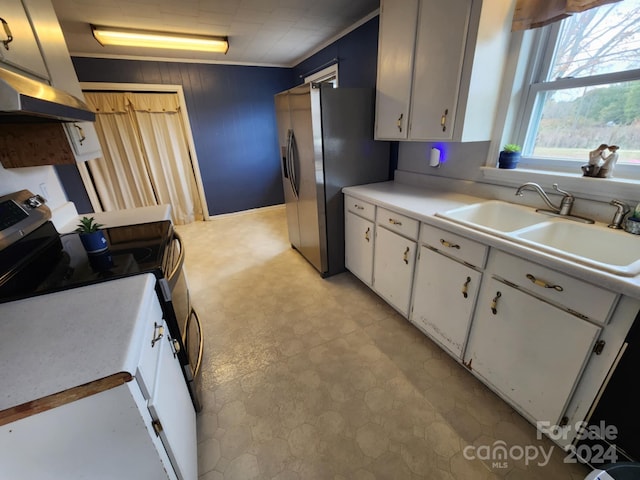 kitchen with white stove, white cabinets, sink, crown molding, and stainless steel fridge