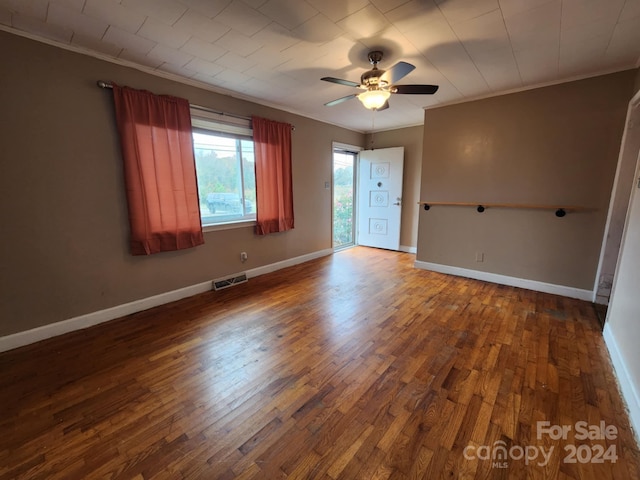 unfurnished room featuring ceiling fan, dark hardwood / wood-style floors, and crown molding