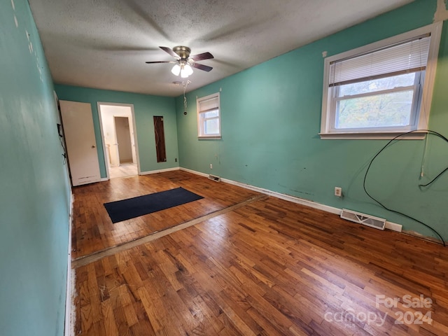 unfurnished room featuring wood-type flooring, a textured ceiling, and ceiling fan