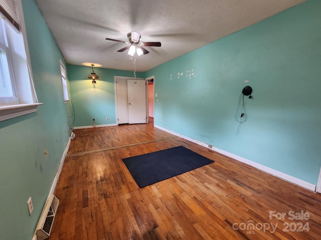 empty room featuring hardwood / wood-style floors, a textured ceiling, and ceiling fan