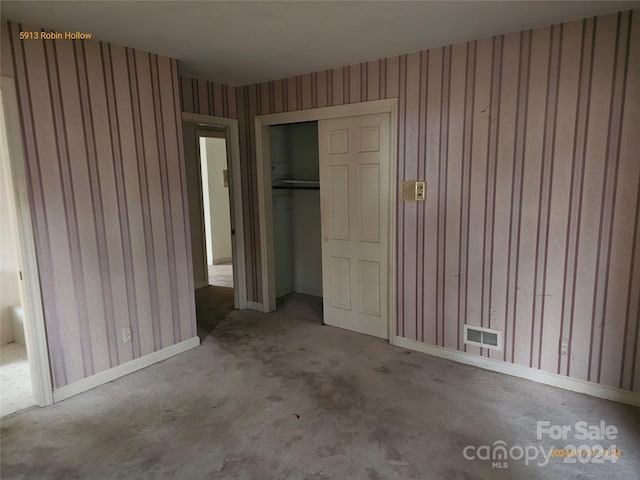 unfurnished bedroom featuring concrete flooring and a closet