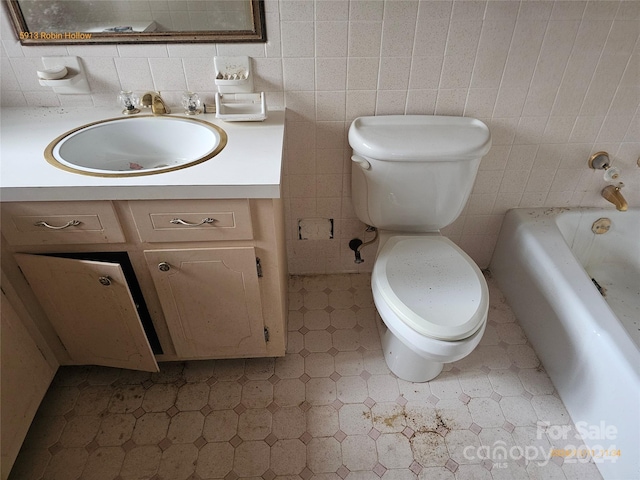 bathroom with tile walls, backsplash, vanity, toilet, and a washtub