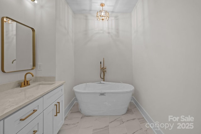 bathroom with a washtub, a notable chandelier, and vanity