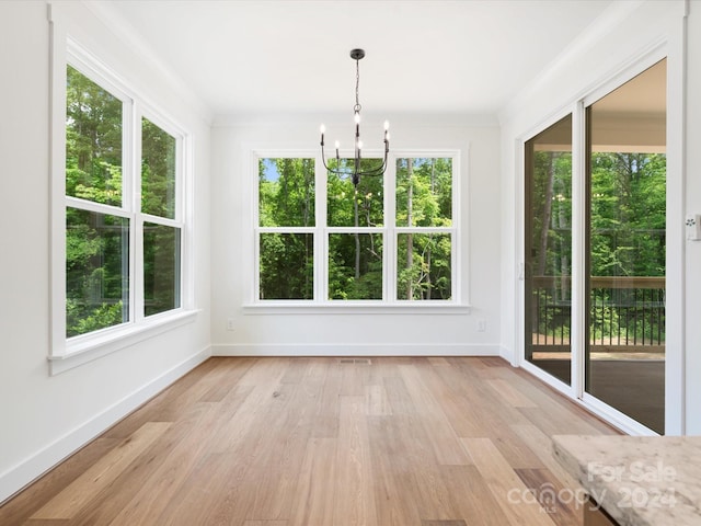 unfurnished sunroom featuring a chandelier and a wealth of natural light