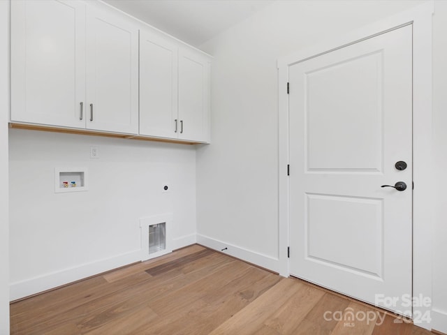 laundry room with cabinets, light hardwood / wood-style floors, hookup for a washing machine, and electric dryer hookup