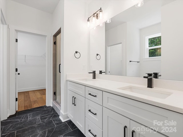 bathroom with a shower with shower door, vanity, and wood-type flooring