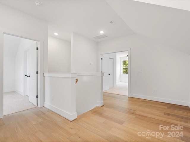 empty room featuring wood-type flooring and lofted ceiling