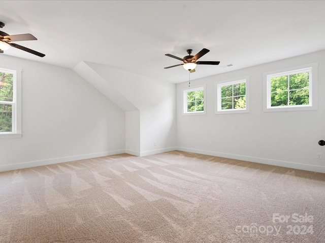 additional living space featuring light colored carpet, ceiling fan, and vaulted ceiling