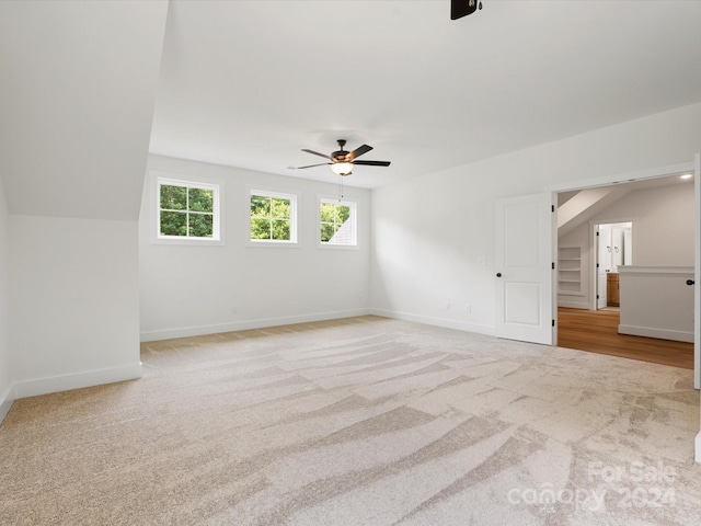 carpeted empty room with vaulted ceiling and ceiling fan