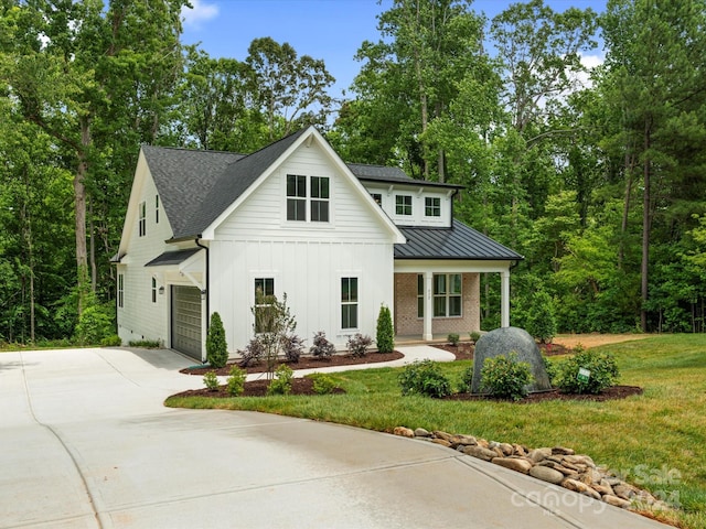 modern inspired farmhouse with a garage and a front lawn