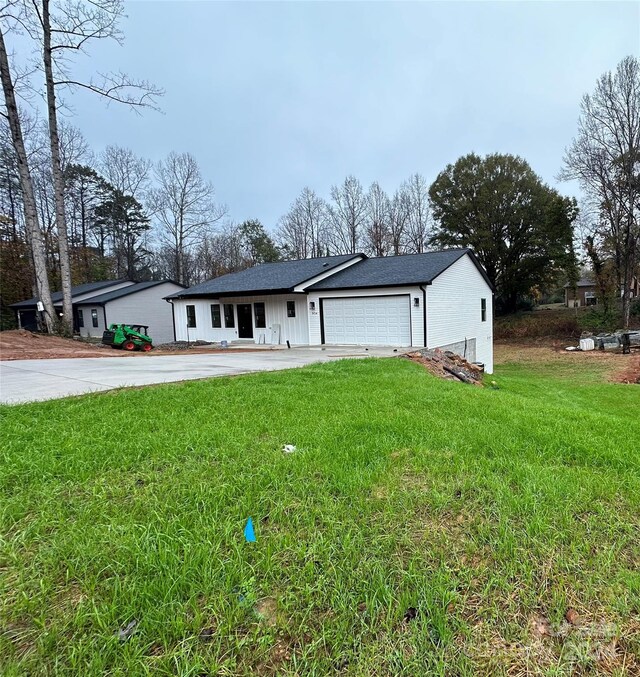 ranch-style house featuring a garage and a front lawn