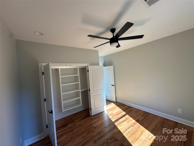 unfurnished bedroom with dark hardwood / wood-style floors, ceiling fan, and a closet