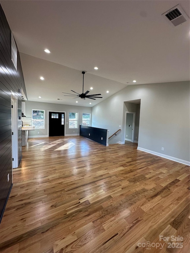 unfurnished living room featuring hardwood / wood-style flooring, ceiling fan, and lofted ceiling