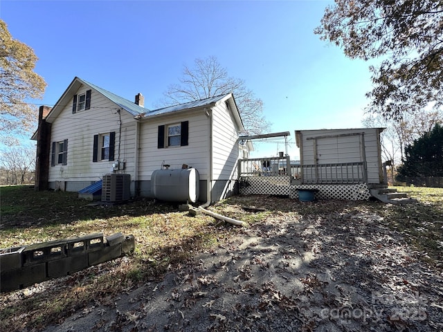 back of house with a wooden deck and cooling unit