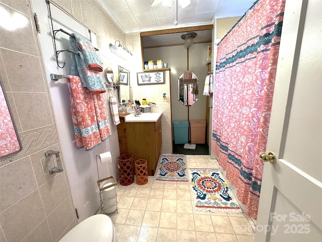 bathroom with tile walls, vanity, ornamental molding, walk in shower, and toilet