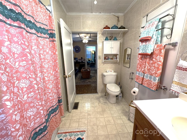 bathroom featuring tile walls, vanity, crown molding, and toilet