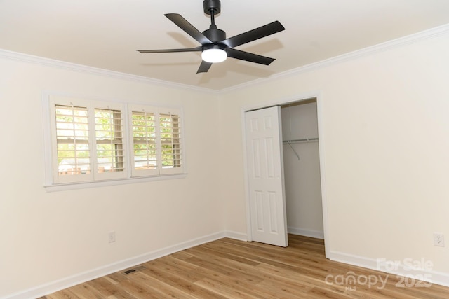 unfurnished bedroom featuring a closet, light hardwood / wood-style flooring, ceiling fan, and crown molding