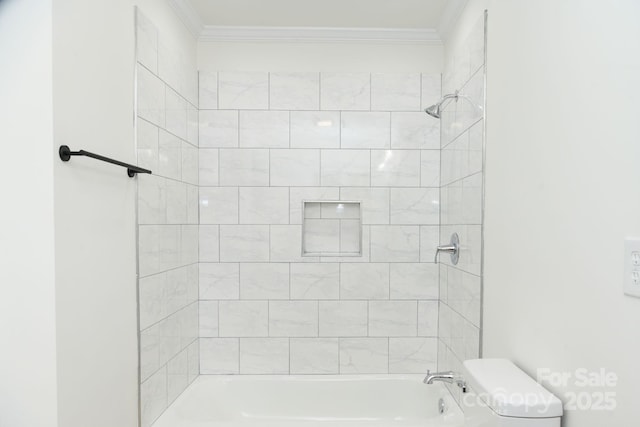 bathroom with crown molding, toilet, and tiled shower / bath