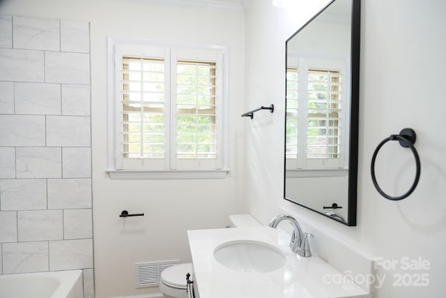 full bathroom featuring washtub / shower combination, vanity, toilet, and ornamental molding