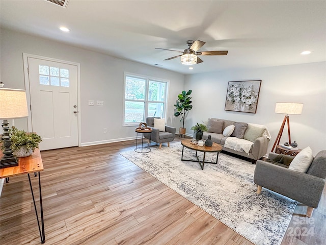 living room featuring light hardwood / wood-style flooring and ceiling fan