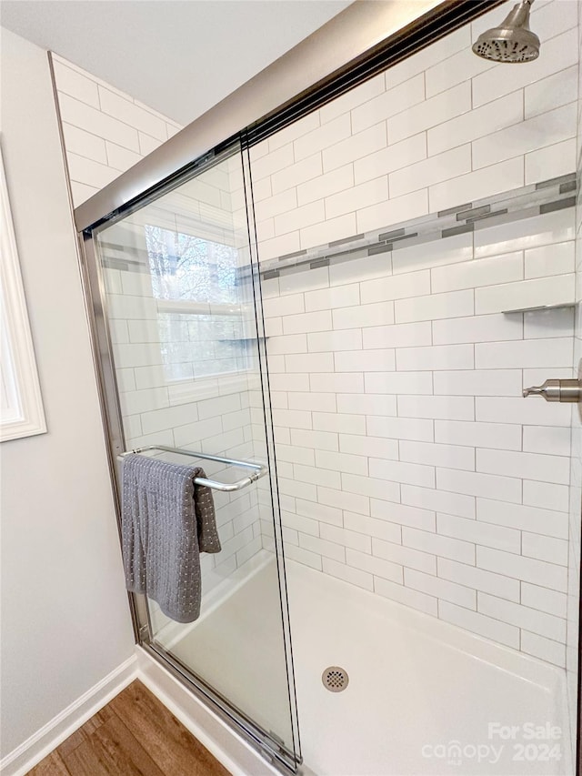 bathroom with hardwood / wood-style floors and a shower with door