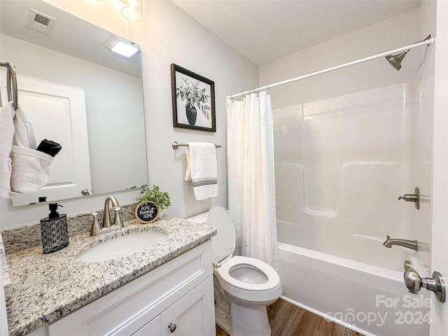 full bathroom featuring wood-type flooring, shower / bath combination with curtain, toilet, and vanity