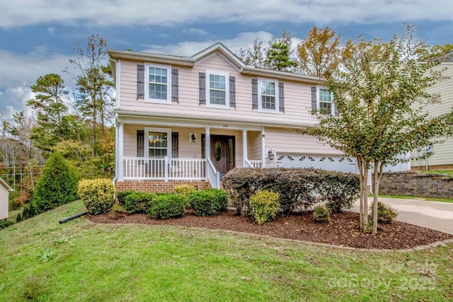 view of front of property with covered porch, a garage, and a front yard