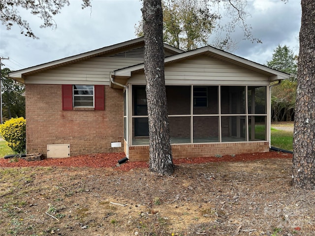 rear view of property featuring a sunroom