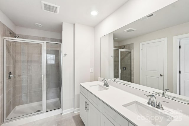 bathroom featuring tile patterned floors, vanity, and a shower with door