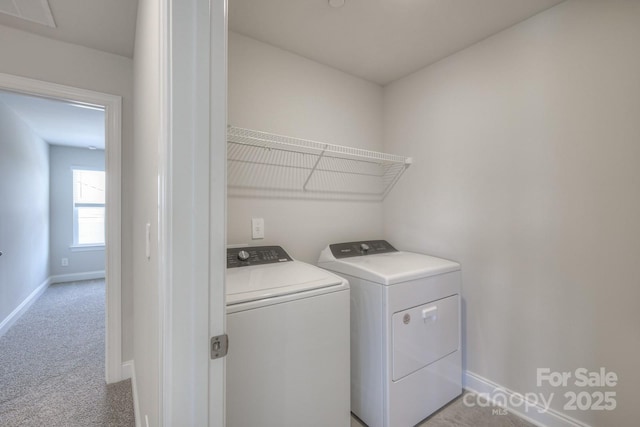 clothes washing area featuring washing machine and dryer and light colored carpet