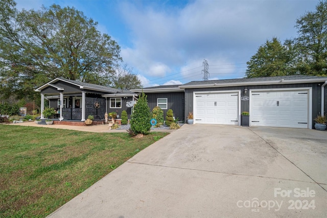 ranch-style home featuring a garage, a porch, and a front yard