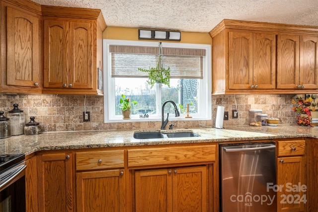 kitchen featuring a textured ceiling, appliances with stainless steel finishes, sink, and tasteful backsplash