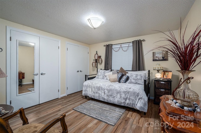 bedroom with a textured ceiling and hardwood / wood-style flooring