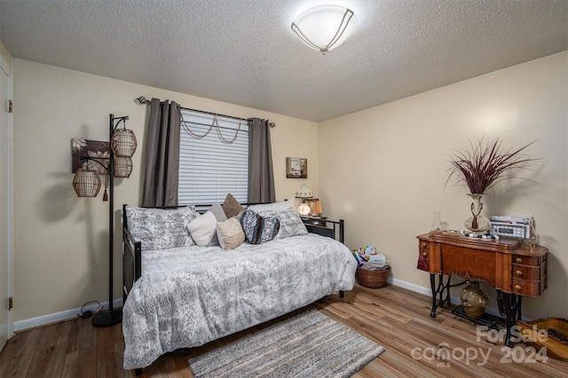 bedroom featuring a textured ceiling and hardwood / wood-style flooring