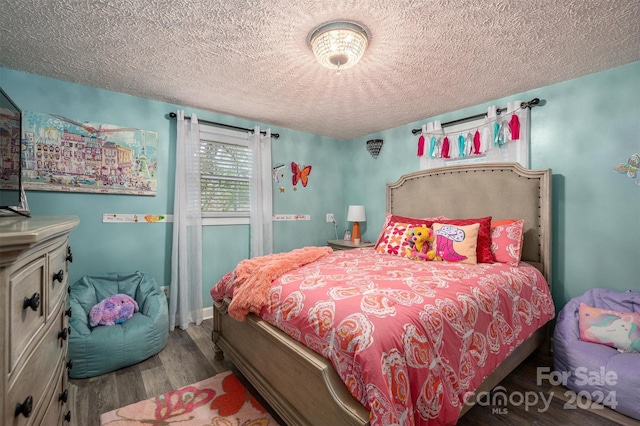 bedroom featuring wood-type flooring and a textured ceiling