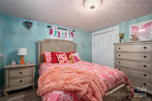 bedroom with dark wood-type flooring, a textured ceiling, and a closet