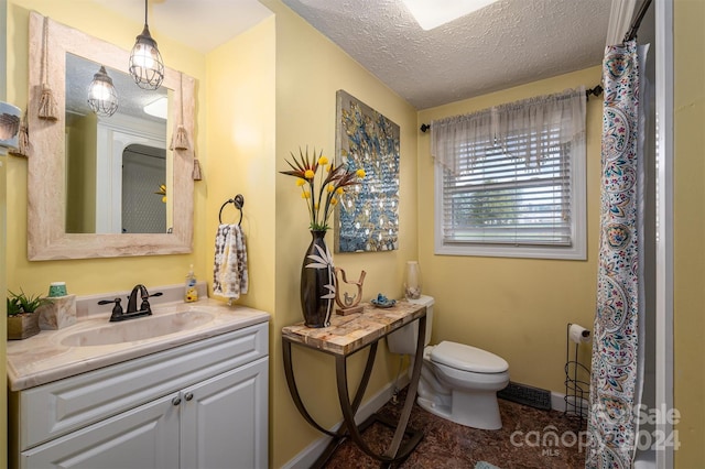 bathroom with vanity, a textured ceiling, and toilet