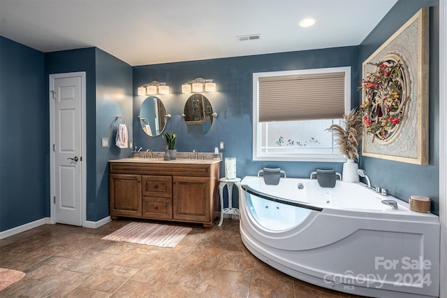 bathroom with a washtub and vanity