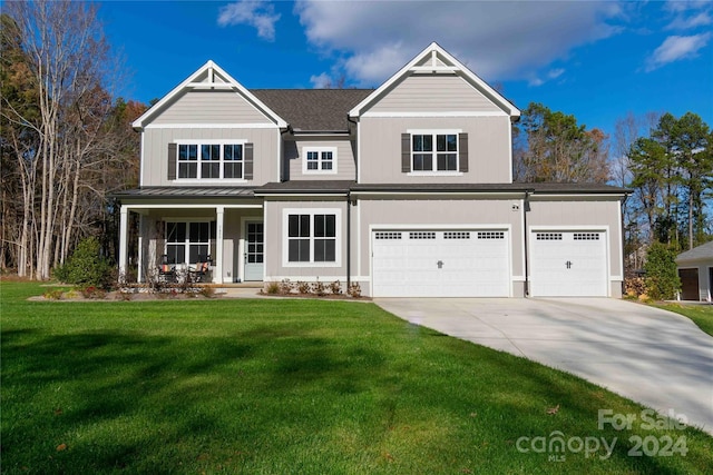 view of front facade with a front yard, a garage, and covered porch