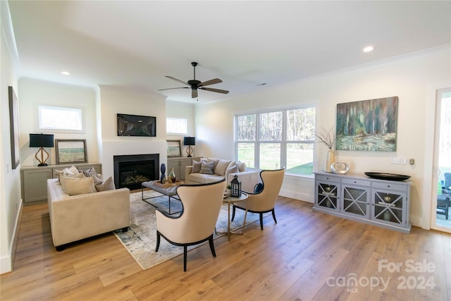 living room featuring ceiling fan, light hardwood / wood-style flooring, and ornamental molding