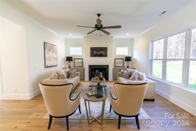 living room featuring ceiling fan, light hardwood / wood-style floors, and crown molding