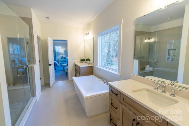 bathroom with tile patterned flooring, vanity, and shower with separate bathtub