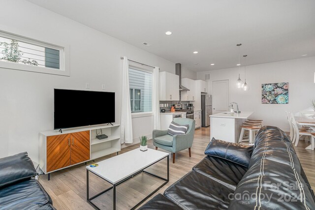 living room with sink and light hardwood / wood-style flooring