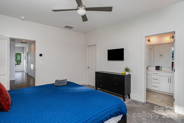 bedroom with hardwood / wood-style flooring, ceiling fan, ensuite bath, and sink